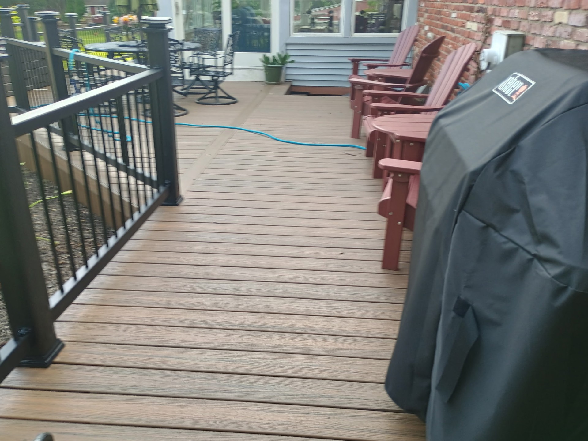 Wide deck platform with Adirondack chairs and grill